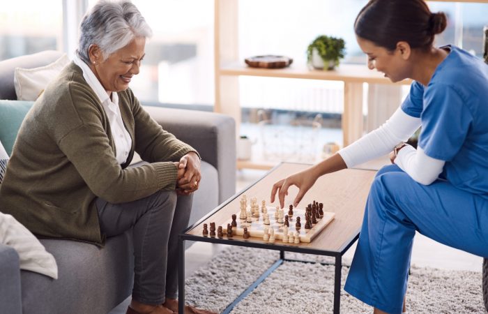 Shot of a young nurse playing chess with a senior woman in a retirement home